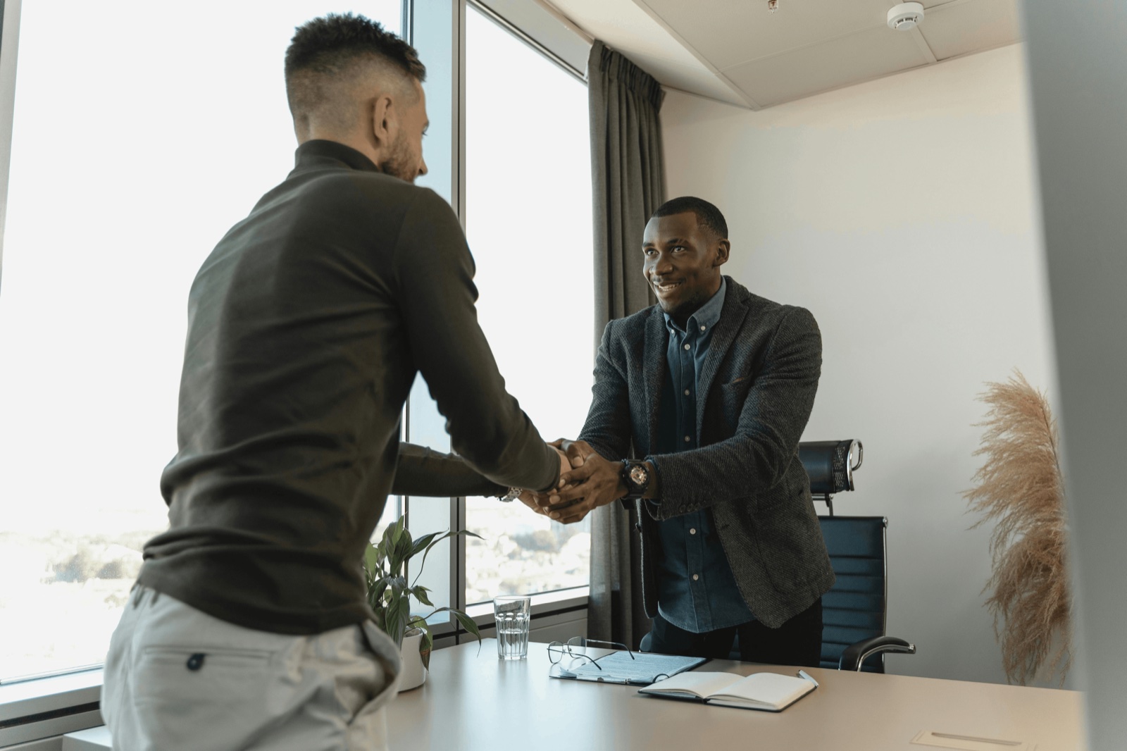 Zwei Männer geben sich in einem Büro die Hand