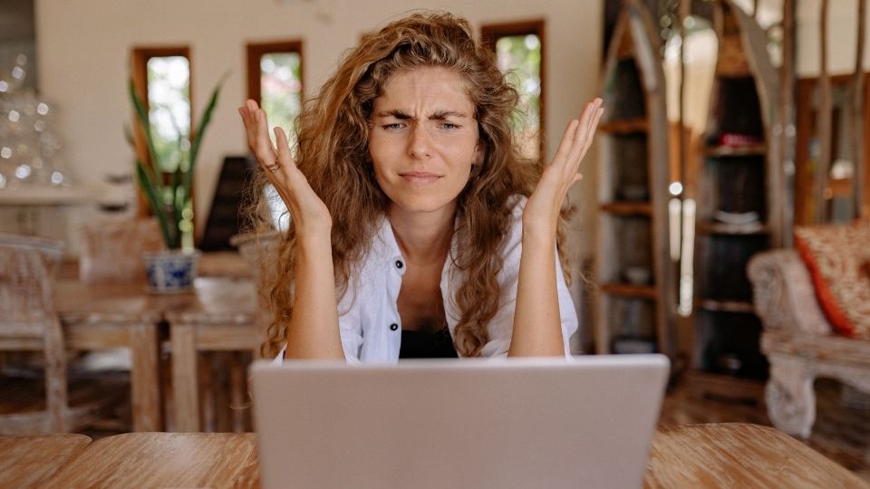 Eine Frau sitzt ratlos vor ihrem Laptop